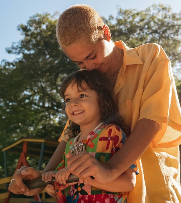 Young queer woman and girl play together at a park